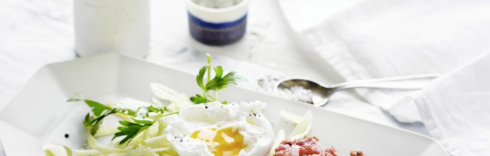 Rindertatar mit pochiertem Ei auf zitronigem Krautsalat