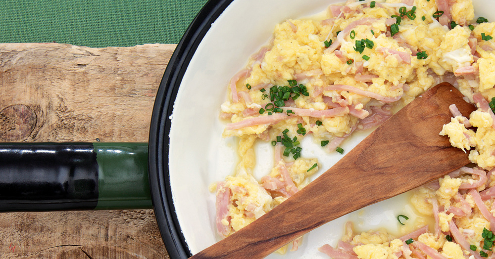 Ein dampfendes Pfannkuchen a uf einer Platte mit Schinkenstreifen.