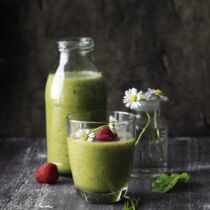 Wellness-Smoothie  mit Blättern und Gänseblümchen