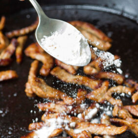 Kalbfleisch-Streifen in einer schweren Pfanne mit Mehl bestäuben - Zürcher Geschnetzeltes Zürcher Geschnetzeltes