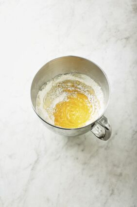 Kürbispüree und Hefeansatz zur Mehlmischung geben. Mit den Knethaken des Handrührgeräts auf kleiner Stufe ca. 6 Min. kneten, bis sich die Zutaten verbunden haben. Weitere 6 Min. auf höchster Stufe zu einem weich-samtigen Teig kneten. Zu einer Kugel formen und zugedeckt ca. 1 Std. gehen lassen. Inzwischen ein Blech mit Backpapier auslegen und 12 Küchengarnstücke à ca. 70 cm Länge zurechtschneiden. Schritt 2