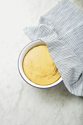 Den Teig auf einer bemehlten Arbeitsfläche durchkneten und zu zwölf gleich großen Kugeln formen. Schritt 3