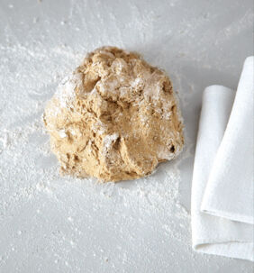 Brot backen Sauerteigbrot Teig mit Mehle bestäuben Brot backen Sauerteigbrot Teig mit Mehle bestäuben