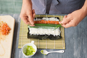 Sushi selber essen Hoso Maki Wasabi und Fisch auf Reis geben