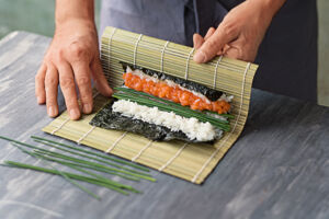 Sushi selber essen Hoso Maki Sushimatte anheben und einrollen