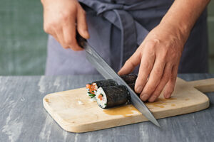 Sushi selber essen Hoso Maki Sushirolle in Stücke schneiden