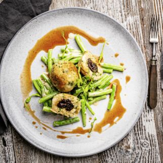 Vegane Speck-knödel mit Pflaumenfüllung, Burgunderrahmund cremigem Bohnensalat Vegane Speck-knödel mit Pflaumenfüllung, Burgunderrahmund cremigem Bohnensalat