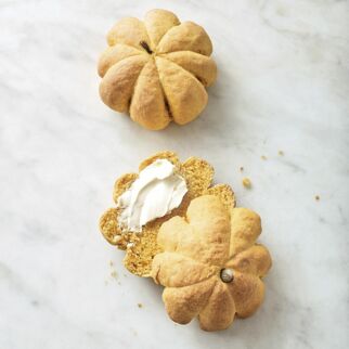 Inzwischen den Backofen auf 200° vorheizen. Jeweils 1 Kürbiskern in die Mitte der Teiglinge stecken. Die Brötchen im heißen Ofen (Mitte) in ca. 15 Min. goldgelb backen. Abkühlen lassen und das Garn entfernen. Schritt 5