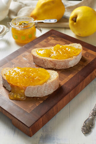 Brotscheiben mit Quittenmarmelade bestrichen auf Holzbrett - Grundrezept Quittenmarmelade Quittenmarmelade auf Brot