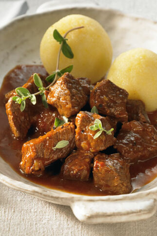Eine Schüssel Gulasch vom Rind serviert mit Kartoffel Klößen | Klassisches Rindergulasch Rezept Klassisches Rindergulasch