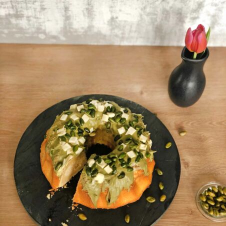 Guglhupf mit Topping aus Pistaziencreme, Pistazien und Stückchen weißer Schokolade. White-Chocolate-Kuchen mit Pistaziencreme