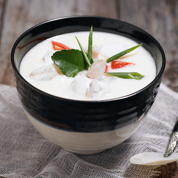 Creamy coconut fish soup with white fish, mushrooms, cherry tomatoes, chilli and herbs