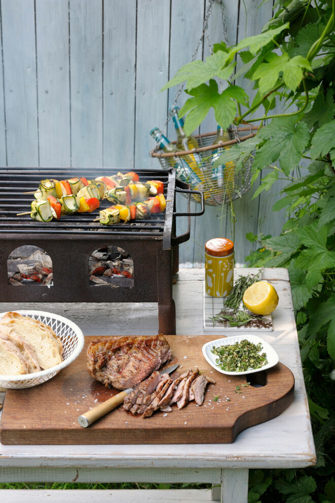 Gegrilltes Lammfleisch auf Holzbrett & Käse-Gemüsespiesse auf Grill Grillen Unterseite Holzkohle-Grill